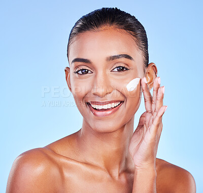 Buy stock photo Skincare, cream and happy with portrait of woman in studio for beauty, facial or moisturizer. Spa treatment, lotion and collagen with face of person on blue background for makeup, glow or sunscreen