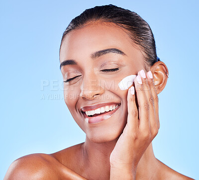 Buy stock photo Skincare, cream and product with face of woman in studio for beauty, facial or moisturizer. Spa treatment, health and collagen with person and lotion on blue background for makeup, glow or sunscreen