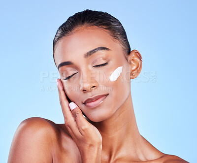 Buy stock photo Skincare, beauty and cosmetics with woman and cream in studio for lotion, facial or moisturizer. Spa, health and collagen with face of person on blue background for makeup, glow or sunscreen