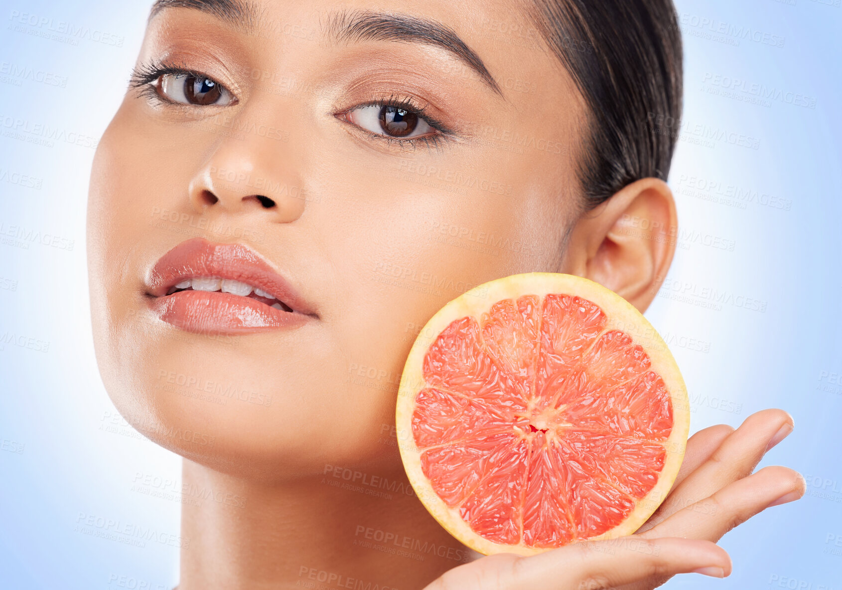 Buy stock photo Portrait, skincare and grapefruit with a natural woman in studio on a blue background for health or wellness. Face, skincare and aesthetic with a young model holding fruit for detox or antioxidants