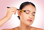 Woman, makeup and eye brush in studio for beauty, skincare or face application on pink background. Young model, dermatology and cosmetics tools for eyeshadow glow, facial powder or aesthetic makeover