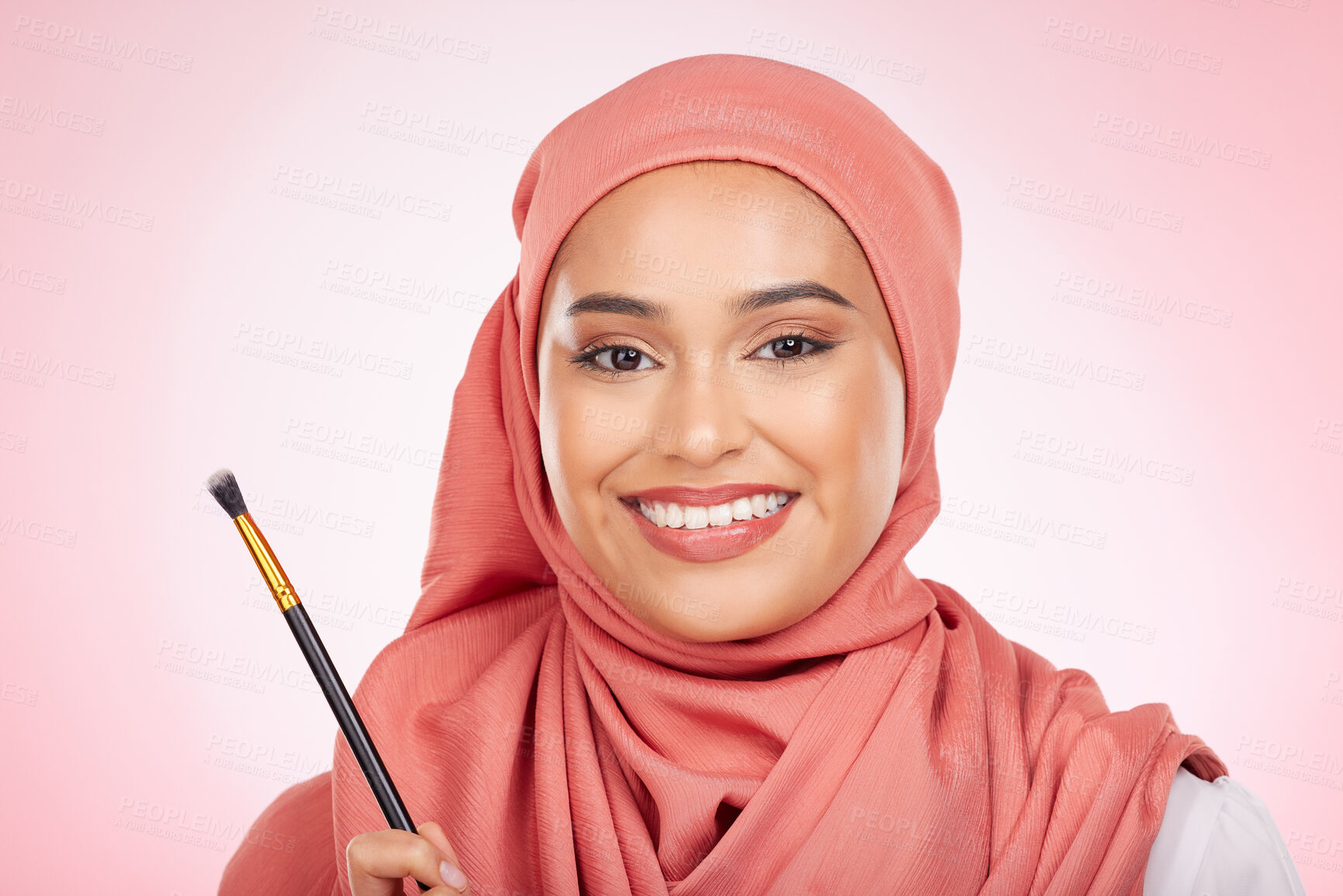 Buy stock photo Beauty, portrait and muslim woman with makeup brush in studio for wellness and cosmetics on pink background. Halal skincare, face and female with hijab for luxury, glamour or Islamic safe products