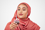 Muslim, woman and cupcake with candle, birthday wish and celebration with dessert isolated on white background. Blowing flame, cake and sweets, hijab and party with event, food and gift in studio