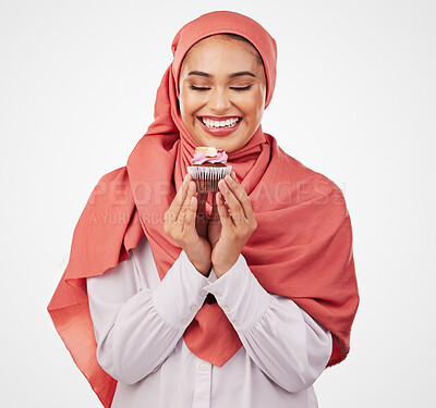 Buy stock photo Smile, cupcake and celebration with a muslim woman in studio on a white background for dessert. Face, food and a happy young islamic person eating a cake, candy or sugar snack at a party event