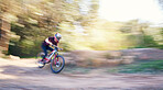 Blur, race and man cycling in nature training for a competition on trail in forest or woods. Action, sports or fast cyclist athlete riding bicycle at speed for cardio exercise, fitness or workout