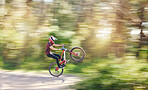 Blur, air and man cycling in nature training for a competition on trail or path in forest or woods. Freedom, stunt or cyclist athlete riding bicycle to jump for cardio exercise, fitness or workout
