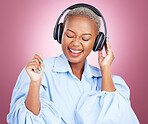 Headphones, dance and happy black woman in studio with music, radio or streaming subscription on pink background. Podcast, earphones or African lady model dancing to album track or feel good playlist