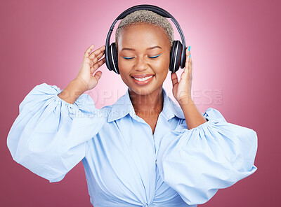 Buy stock photo Music, headphones and happy black woman in studio for radio, streaming or audio subscription on pink background. Podcast, earphones and African lady model smile for album track or feel good playlist