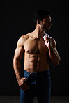 Sexy, muscle and topless man on dark background with fitness inspiration, beauty aesthetic and sensual fashion. Erotic art, sexual body and male model in studio thinking in fantasy lighting and jeans