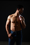 Sexy, muscle and man in studio with fitness inspiration, beauty aesthetic and sensual fashion. Erotic art, sexual body and male model on black background, thinking in dark lighting with jeans and abs
