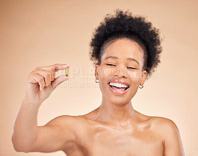 Buy stock photo Skincare, black woman and happy for pill, beauty and isolated on a brown background in studio. Excited, natural cosmetics and fish oil supplements, healthy biotin vitamin or omega 3 of African model