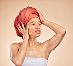 Hair, scarf and black woman in studio for wellness, beauty or natural cosmetics on brown background. Headwrap, pride and African lady model with glowing or skincare satisfaction, results or treatment
