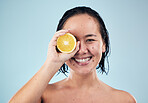 Portrait, mockup or happy woman with orange for skincare or beauty in studio on blue background. Smile, dermatology shine or Asian person with natural fruits, vitamin c or face glow for wellness