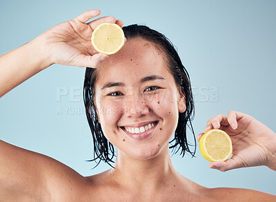 Buy stock photo Portrait, smile or happy woman with lemon for skincare or beauty in studio on blue background. Dermatology, shine or Asian person with natural fruits, vitamin c or face glow for wellness or health
