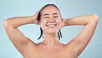 Shower, water or happy woman cleaning hair or body for wellness in studio on blue background. Smile, beauty or wet female person washing or grooming for healthy natural hygiene or skincare to relax