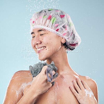 Buy stock photo Happy woman, shower and water drops with loofah in hygiene, grooming or washing against a blue studio background. Female person in relax body wash, cleaning or skincare routine under rain in bathroom