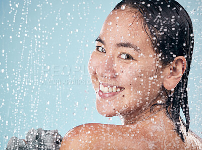 Buy stock photo Portrait, woman and shower with water, soap and sponge for cleaning with dermatology, skincare and blue background in studio. Person, smile and washing skin and body with foam bubbles in bathroom