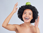 Apple, balance and black woman with health, organic and diet for wellness and healthy in studio. Excited, smile and happy model with green fruit, skin nutrition and vegan food with grey background