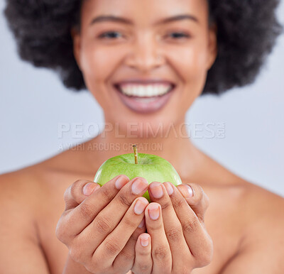 Buy stock photo Apple, black woman and hand closeup with health, diet and natural skincare glow in studio. Happy, face and fruit for healthy nutrition, grey background and wellness with a smile from organic food