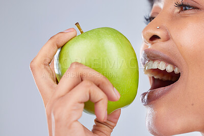 Buy stock photo Apple, black woman and eating with health, diet and natural skincare glow in studio. Happy, face and fruit closeup for healthy nutrition, grey background and balance with a smile from organic food