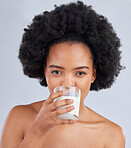 Woman, portrait and drink milk in studio for healthy skin, diet and calcium on white background. Face of african model, dairy smoothie or glass of vanilla milkshake for nutrition, wellness and beauty