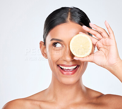 Buy stock photo Face, beauty and lemon with a natural woman in studio on a white background for vitamin C nutrition. Smile, skincare and fruit with a happy young model looking confident in organic treatment