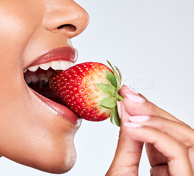Buy stock photo Diet, closeup and woman eating strawberry in a studio for healthy wellness snack for nutrition. Health, beauty and zoom of female model mouth with fruit for natural skin detox by a white background.