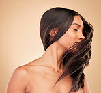 Hair care, beauty and woman shake head in studio isolated on a brown background. Hairstyle, natural cosmetics and model in salon treatment for texture growth, balayage and aesthetic for wellness.