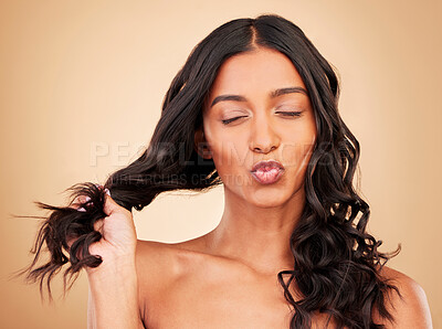 Buy stock photo Happy, hair care and a woman with a pout on a studio background for wellness, beauty or curls. Health, cosmetics and an Indian model or girl with a hairstyle and kiss on a backdrop with confidence