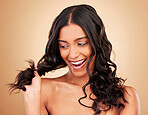 Woman, curly and hair in studio for beauty, shine and keratin shampoo on brown background. Happy young indian model, hairstyle and waves for aesthetic texture, healthy growth and salon cosmetics 