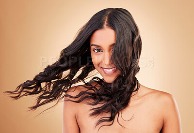 Buy stock photo Portrait, woman and curly hair in wind on studio background for shine, beauty and keratin shampoo. Happy indian model, hairstyle and waves in breeze for aesthetic texture, growth and salon cosmetics