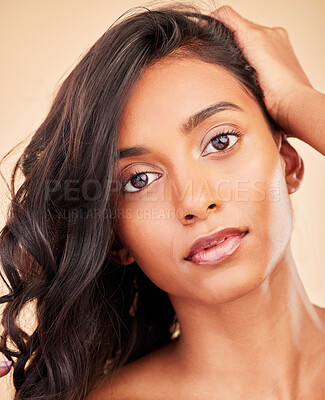 Buy stock photo Hair care, beauty and face of woman in studio isolated on a brown background. Curly hairstyle, makeup cosmetics or portrait of serious Indian model in salon treatment for health, wellness or balayage