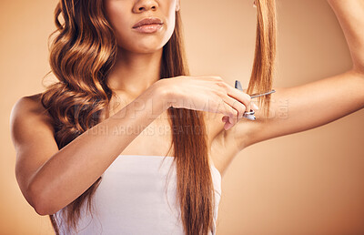 Buy stock photo Scissors, studio and person cut hair, split ends or growth maintenance for self care routine, treatment or grooming texture. Hairdressing product, haircut transformation and model on brown background