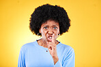 Angry portrait, woman and secret for noise, drama and privacy on yellow background in studio. Face, moody african model and warning with finger on lips for whisper sign, quiet emoji and silence voice