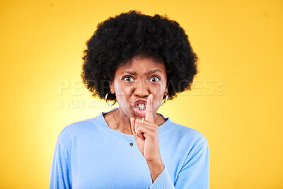 Buy stock photo Angry portrait, woman and secret for noise, drama and privacy on yellow background in studio. Face, moody african model and warning with finger on lips for whisper sign, quiet emoji and silence voice