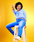 Black woman, peace and sign with hands on chair in studio, yellow background or natural happiness with casual fashion and style. African, gen z or model smile and relax for creative, mockup or space
