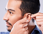 Deaf, cochlear and asian man ear in studio with hearing aid, audio and implant installation. Audiology, sound waves and face of Japanese guy with a disability, vibration or communication device