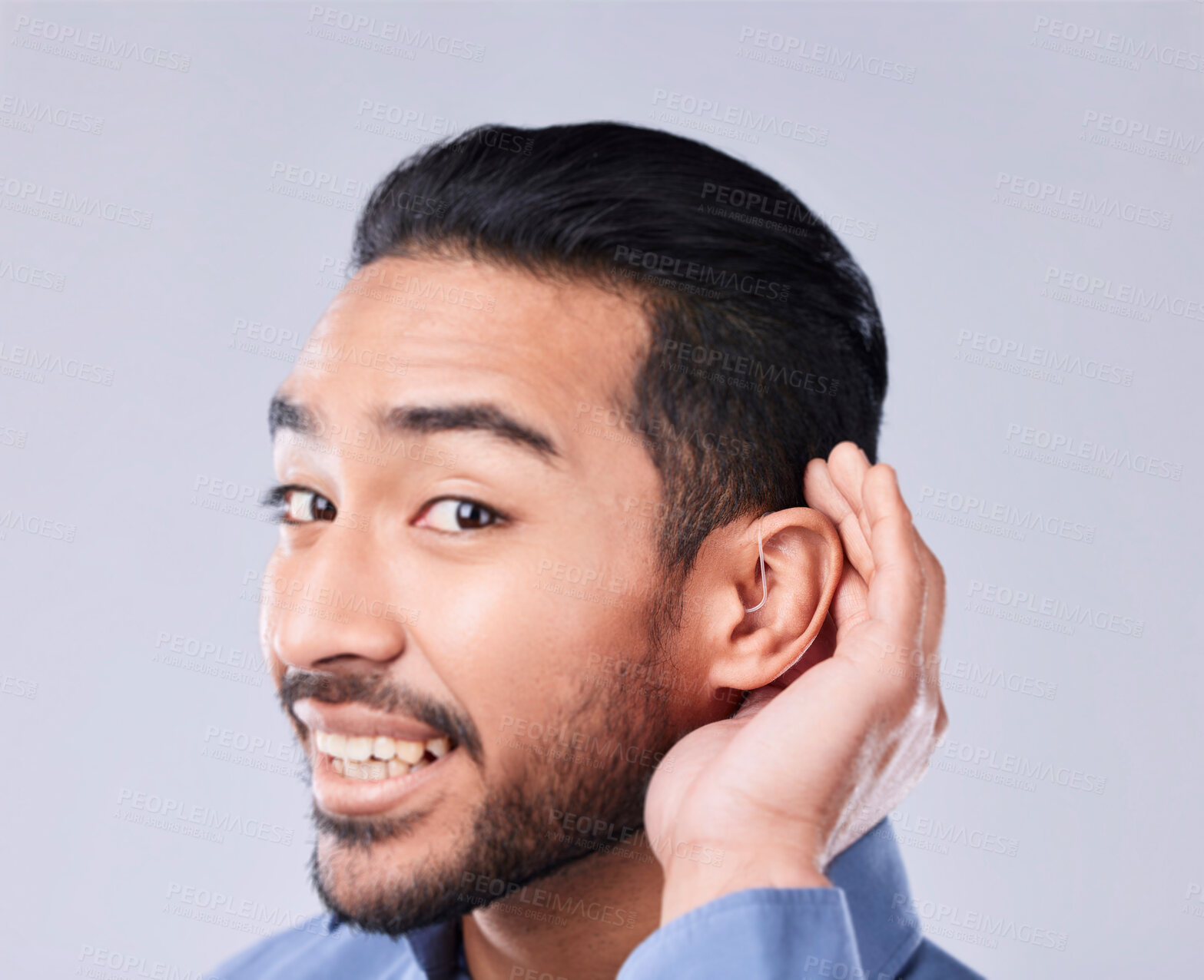 Buy stock photo Deaf, portrait and asian man with hand on cochlear in studio for speak up, listen or communication on grey background. Hearing aid, face and Japanese guy with a disability, emoji and sign for implant