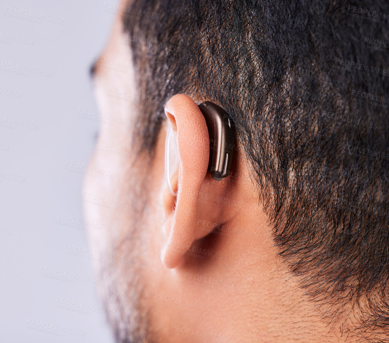 Buy stock photo Ear, deaf and hearing aid closeup in studio on a gray background for sound, audio or communication. Technology, listening and a man with a disability closeup for implant or medical innovation 