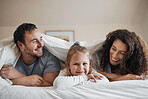 Love, happy and child in bed with her parents for bonding, relaxing and resting together with blanket. Smile, excited and portrait of girl kid laying with mother and father in bedroom of family home.