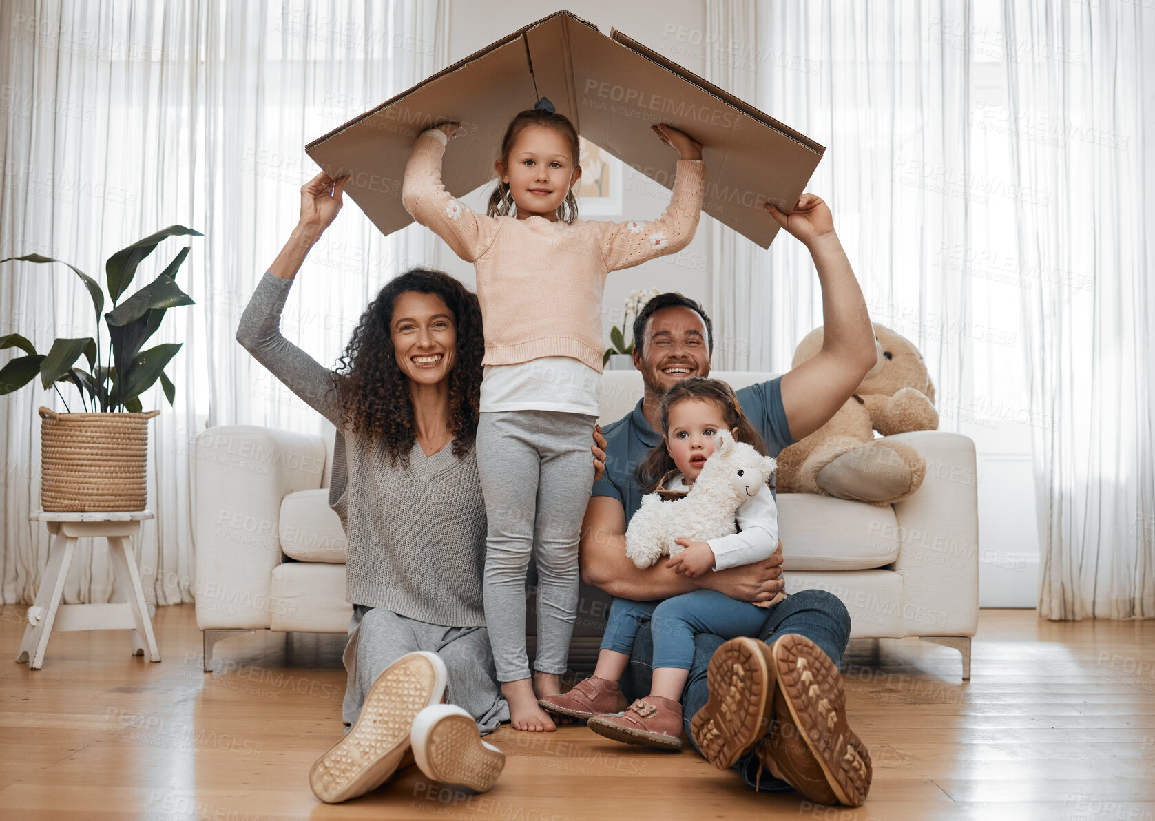 Buy stock photo Parents, children and cardboard roof in portrait, smile or excited for security, real estate or fresh start in family home. Mother, dad and kids on floor, box and happy together for support in house