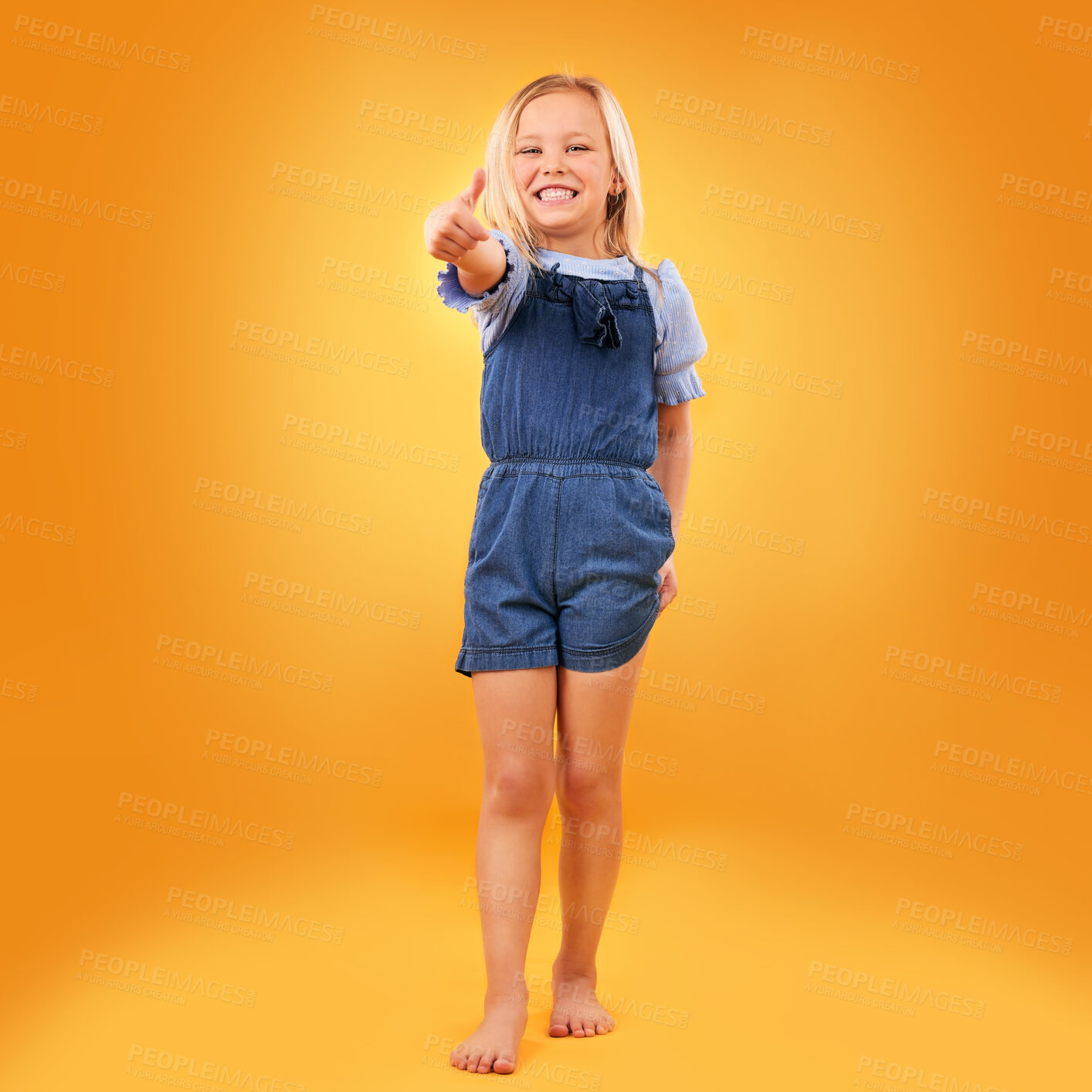 Buy stock photo Happy, portrait of child and thumbs up in studio for support, like emoji or yes approval. Excited girl kid on orange background or space for hand gesture, barefoot or sign for agreement or thank you