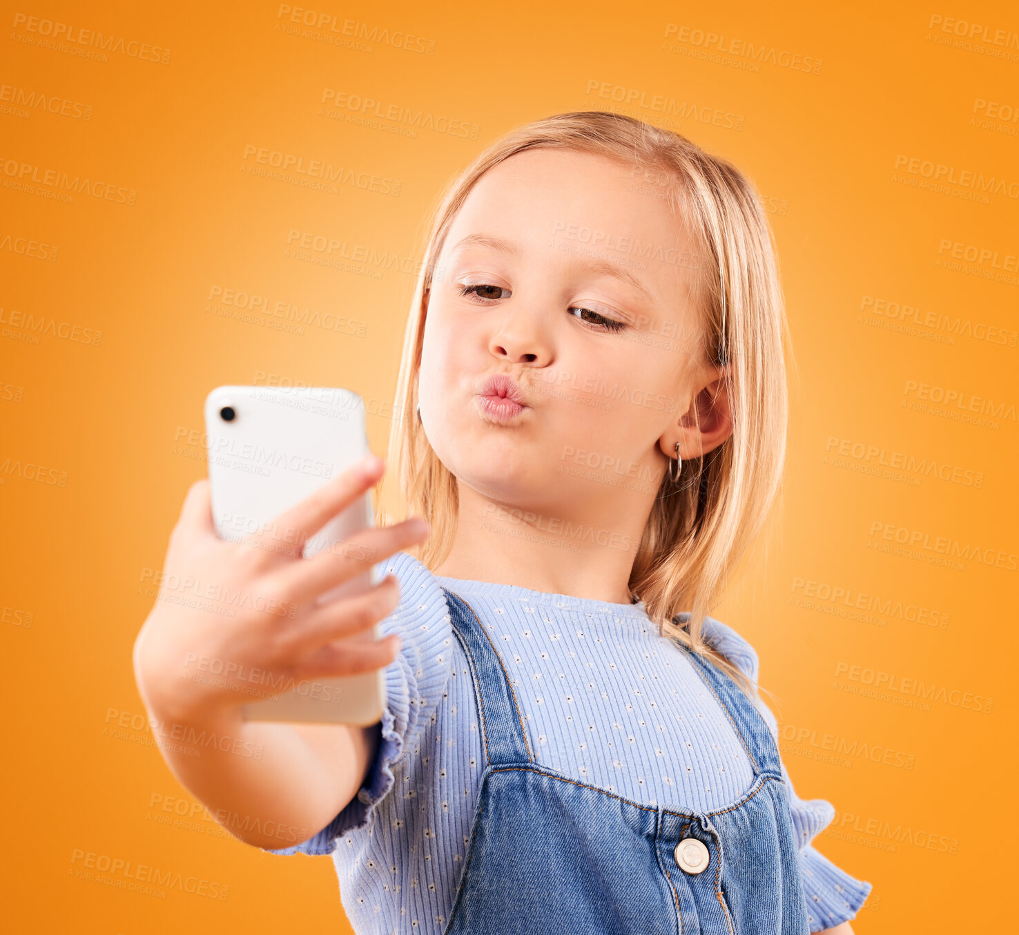 Buy stock photo Kiss, selfie or face of kid in studio with confidence or mockup space in photograph memory. Web, orange background or young girl taking fun pictures online on a social media app to post on internet