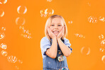 Girl child, face and bubbles, playing and fun with youth isolated on orange background. Liquid soap, happy and portrait with young kid from Australia in studio, playful and toys with childhood 