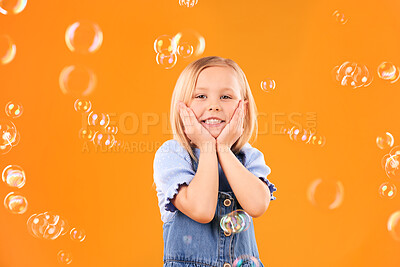 Buy stock photo Girl child, face and bubbles, playing and fun with youth isolated on orange background. Liquid soap, happy and portrait with young kid from Australia in studio, playful and toys with childhood 