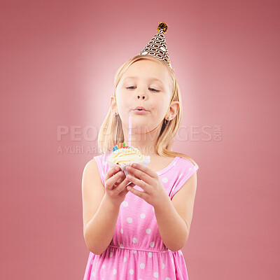 Blow candle, birthday and child with cupcake for holiday party, happy celebration and a wish. Young girl kid on a pink background for surprise, cake or celebrate achievement with a dessert and joy