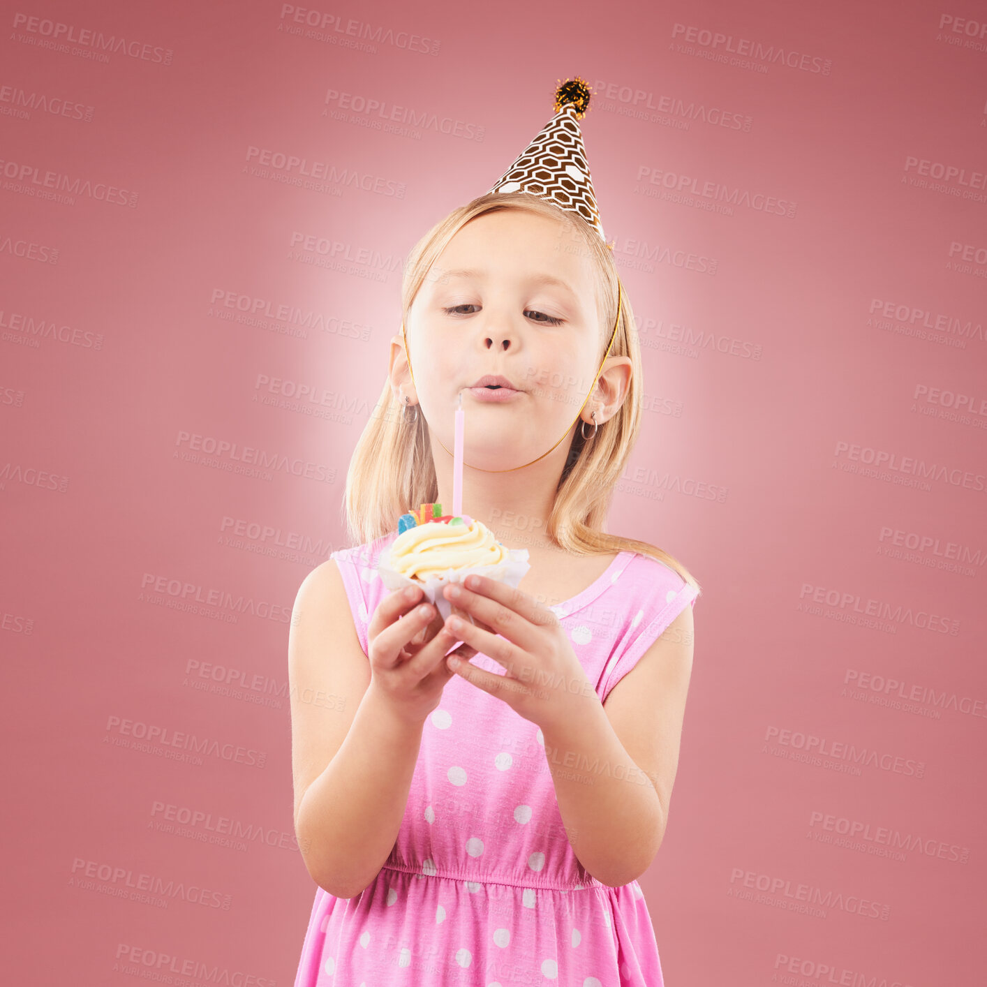 Buy stock photo Blow candle, birthday and child with cupcake for holiday party, happy celebration and a wish. Young girl kid on a pink background for surprise, cake or celebrate achievement with a dessert and joy