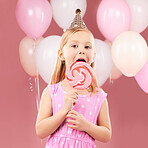 Balloons, lollipop and portrait of child on pink background for birthday party, celebration and special day. Happy, excited and young cute girl smile with candy, sweet treats and dessert in studio