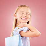 Portrait, girl kid with shopping bag or gift, customer and purchase with fashion or birthday party on pink background. Retail, smile and child with present, luxury and event with happiness in studio