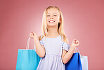 Portrait, happy and girl kid with shopping bag, customer and purchase with fashion isolated on pink background. Retail, smile and young child with gift, luxury and buying, discount and sale in studio